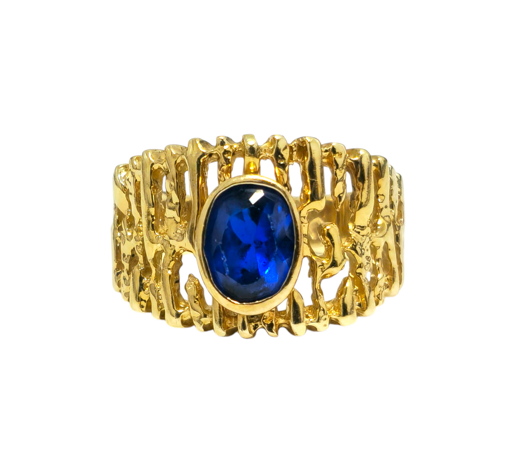 Natural blue sapphire ring in 14k gold with a mid-century design, featuring a polished gold band and a central blue sapphire gemstone.