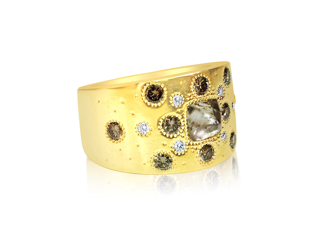 18K yellow gold ring by De Beers featuring a rough diamond with a textured band and elegant design.