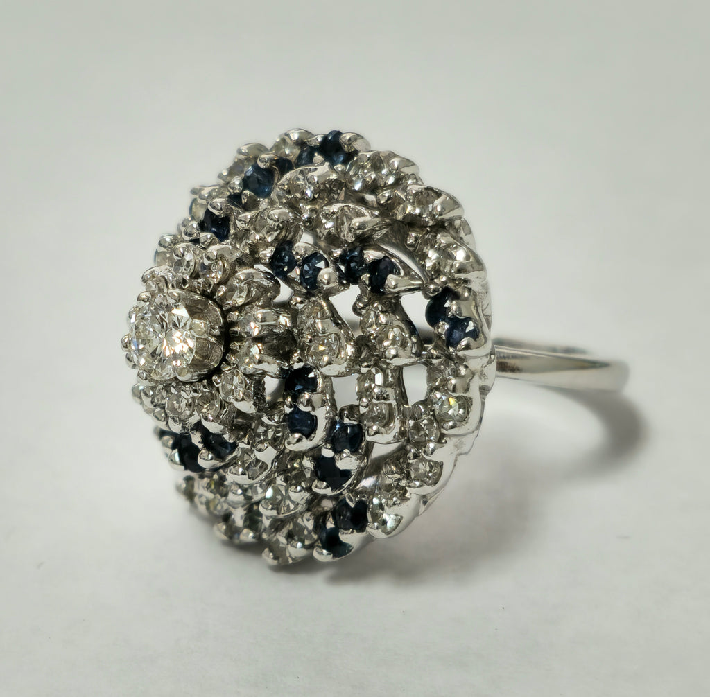 Diamond and blue sapphire cocktail ring featuring a 3.00 carat diamond center stone and intricate band design by Prince The Jeweler.